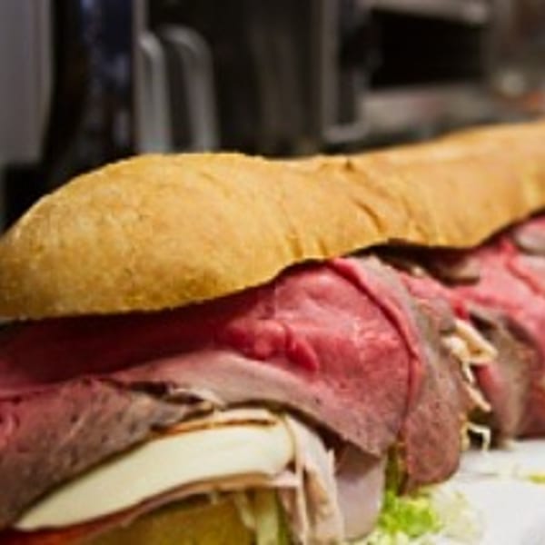 Close-up of a large Rinaldi's Italian Deli sub sandwich with roast beef, cheese, and lettuce.