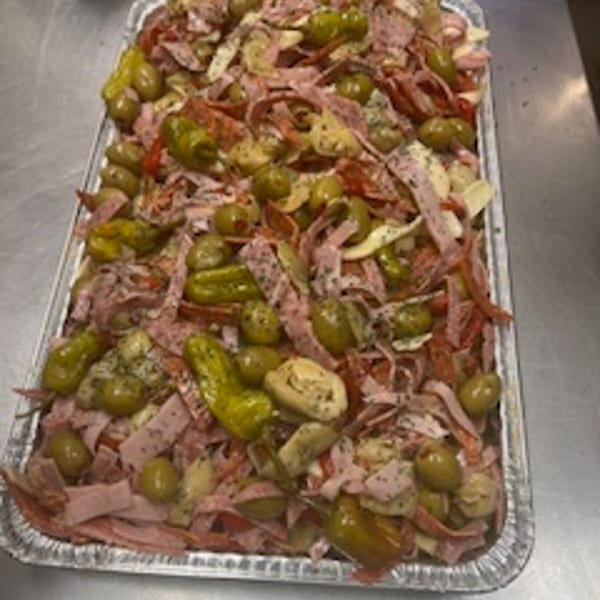 A large catering tray from Rinaldi's Italian Deli filled with sliced meats, olives, and pickled vegetables.